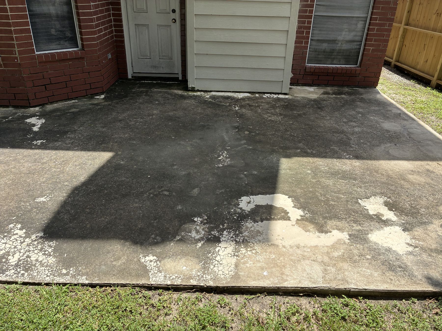 Back patio before washing — heavy organic growth and staining